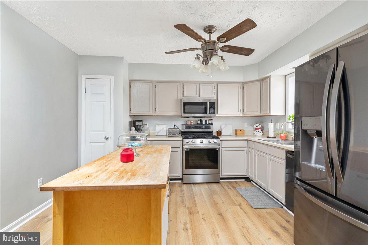 10346 Groves Farm Road Midland, VA 22728 - Photo 9 of 36 a kitchen with a sink stainless steel appliances and white cabinets