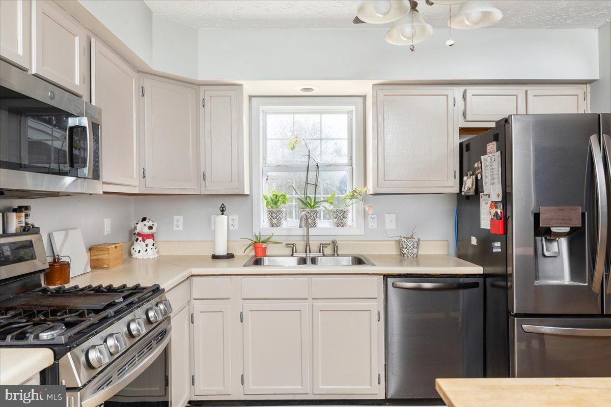 10346 Groves Farm Road Midland, VA 22728 - Photo 10 of 36 a kitchen with stainless steel appliances a sink stove and refrigerator