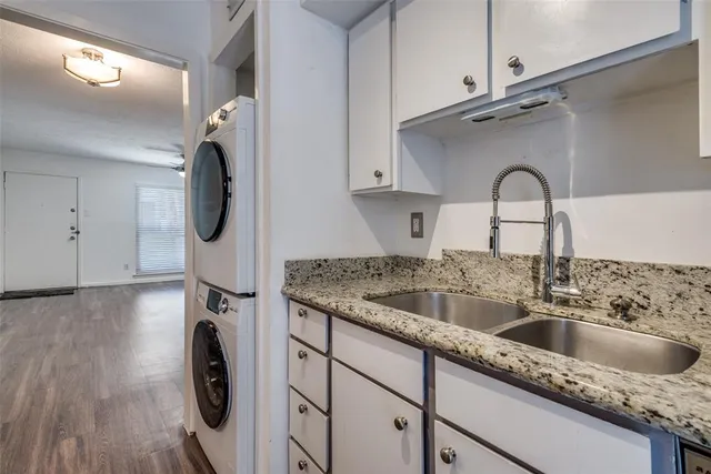 an empty room with wooden floor chandelier fan and windows