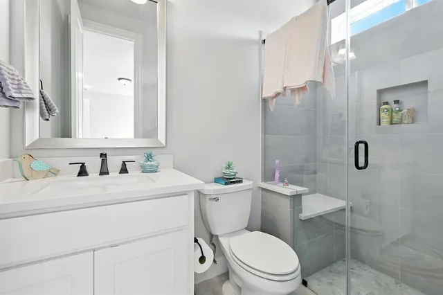 a bathroom with a toilet sink vanity and mirror