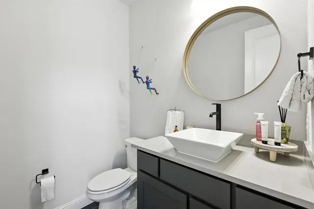 a bathroom with a sink a toilet and a mirror