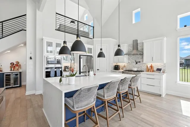 a dining hall with stainless steel appliances kitchen island granite countertop a table chairs and a stove