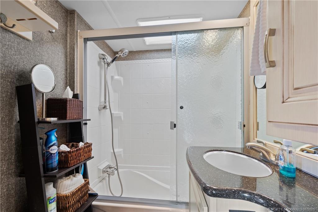 Undisclosed Address Jensen Beach, FL 34957 - Photo 18 of 47 a bathroom with a granite countertop sink mirror and shower