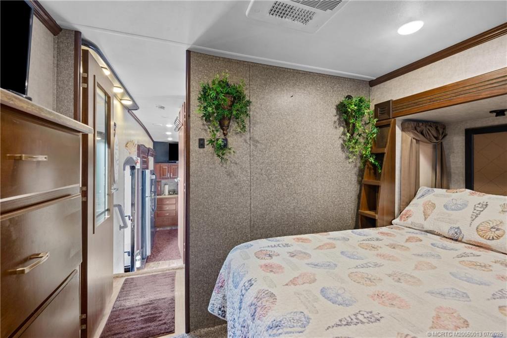 Undisclosed Address Jensen Beach, FL 34957 - Photo 32 of 47 a bedroom with a bed and a potted plant on the dresser