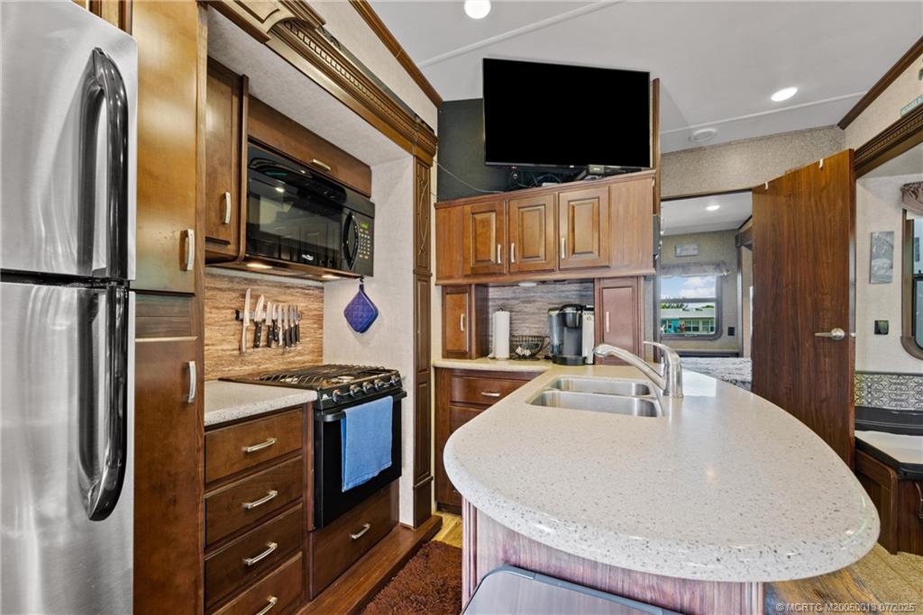 Undisclosed Address Jensen Beach, FL 34957 - Photo 33 of 47 a kitchen with stainless steel appliances a stove a microwave and a refrigerator
