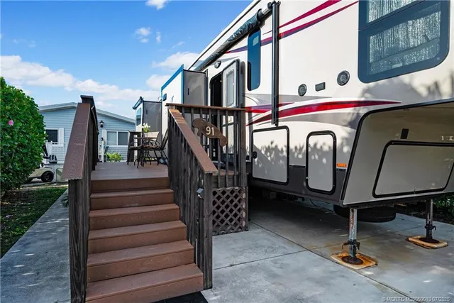 a front view of house with stairs and outdoor seating