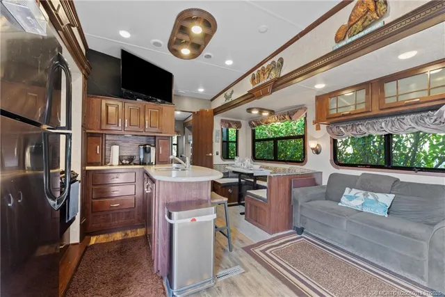 a kitchen with kitchen island a large counter top space appliances and a ceiling fan