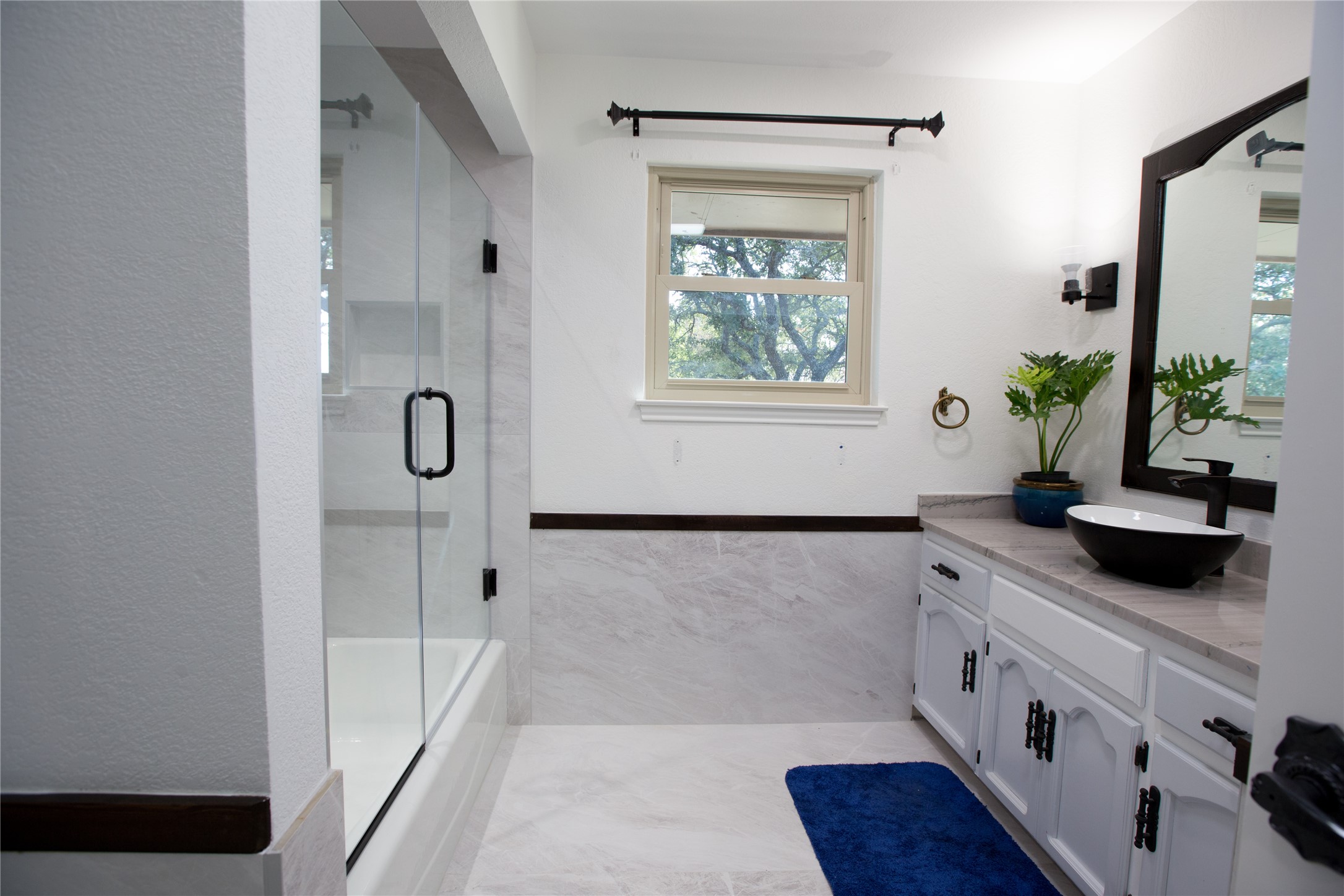 3517 Gattis School Road Round Rock, TX 78664 - Photo 5 of 16 A well-appointed bath features a sleek vessel sink and a clear glass shower enclosure, creating a spa-like atmosphere.