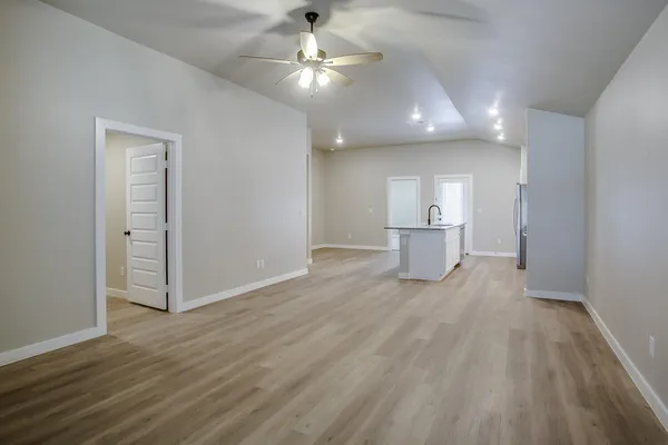 a view of a big room with wooden floor and windows