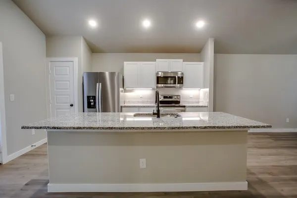 a kitchen with kitchen island stainless steel appliances a sink and stove