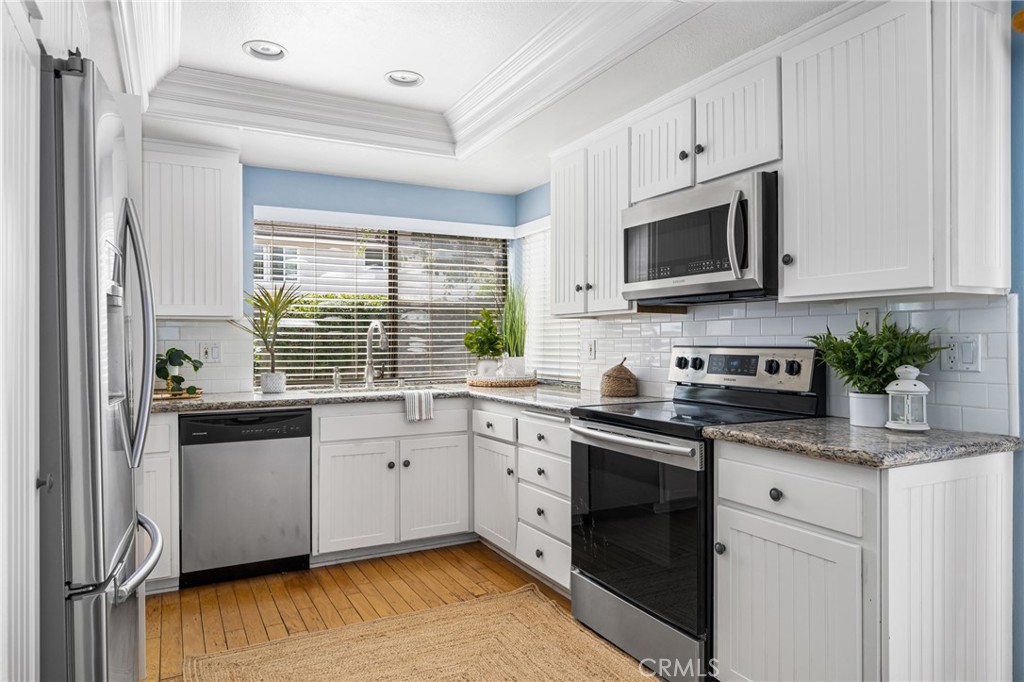 10 Brookstone Avenue Irvine, CA 92604 - Photo 22 of 67 a kitchen with granite countertop white cabinets and white appliances