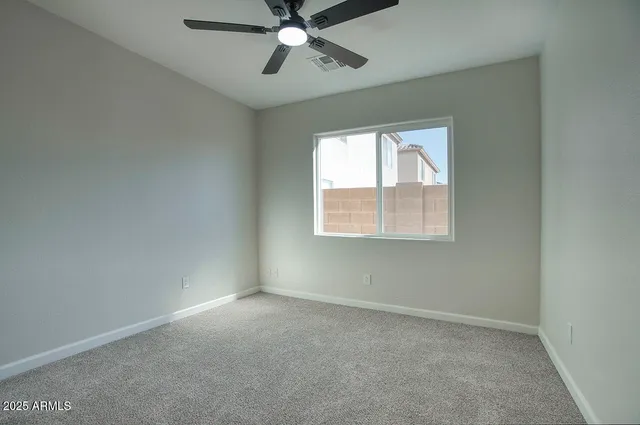 an empty room with a window and a fan