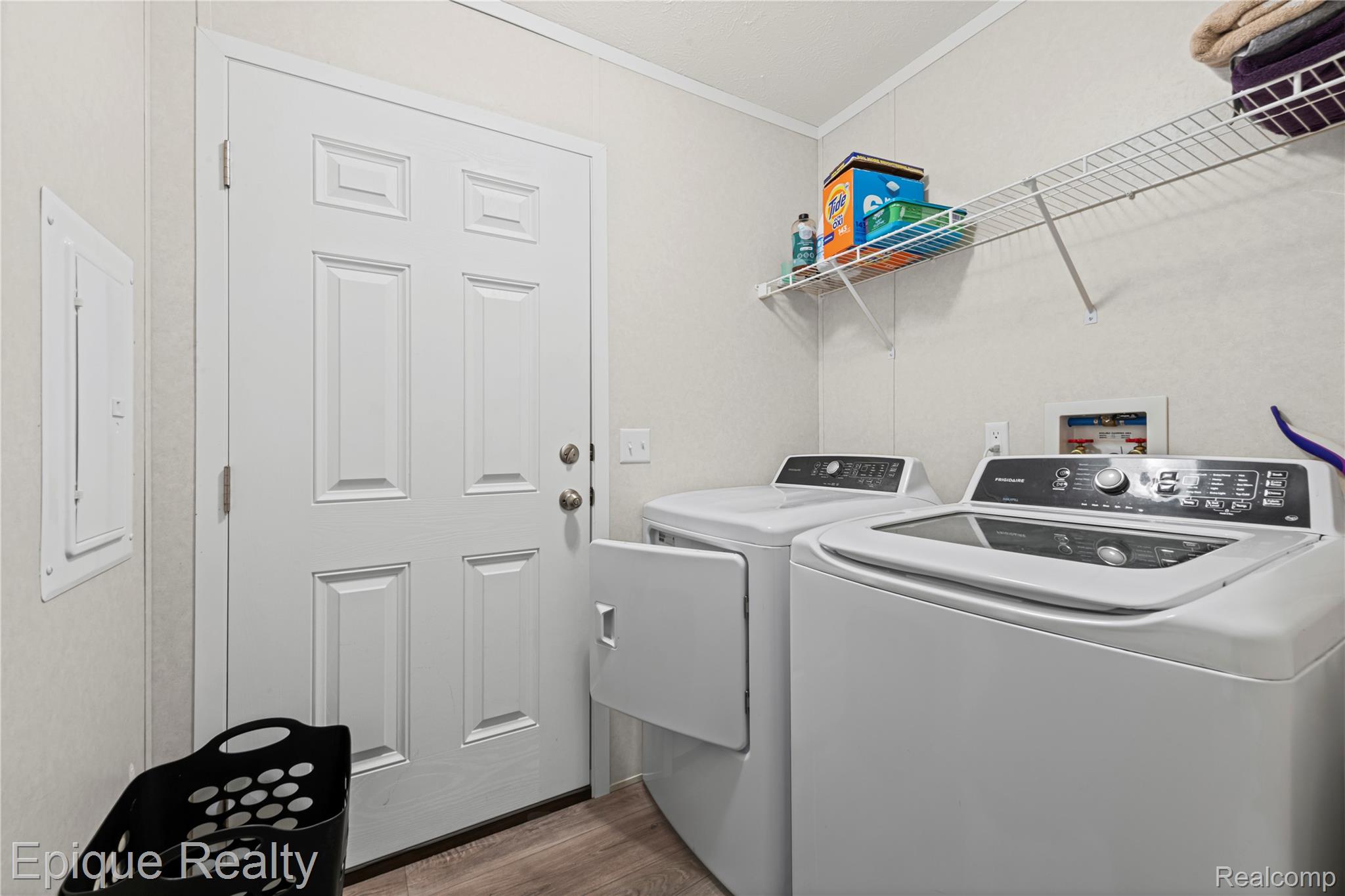 83 Elm Highland, MI 48357 - Photo 17 of 27 Laundry room with ornamental molding, light wood finished floors, electric panel, and separate washer and dryer