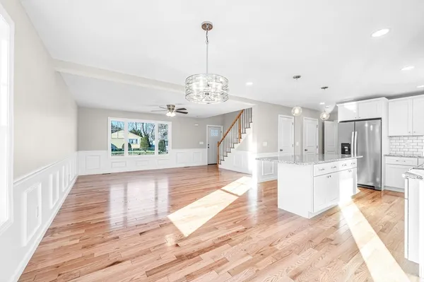 a view of a hallway with wooden floor and a chandelier