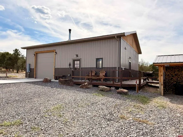 a backyard of a house with barbeque oven table and chairs