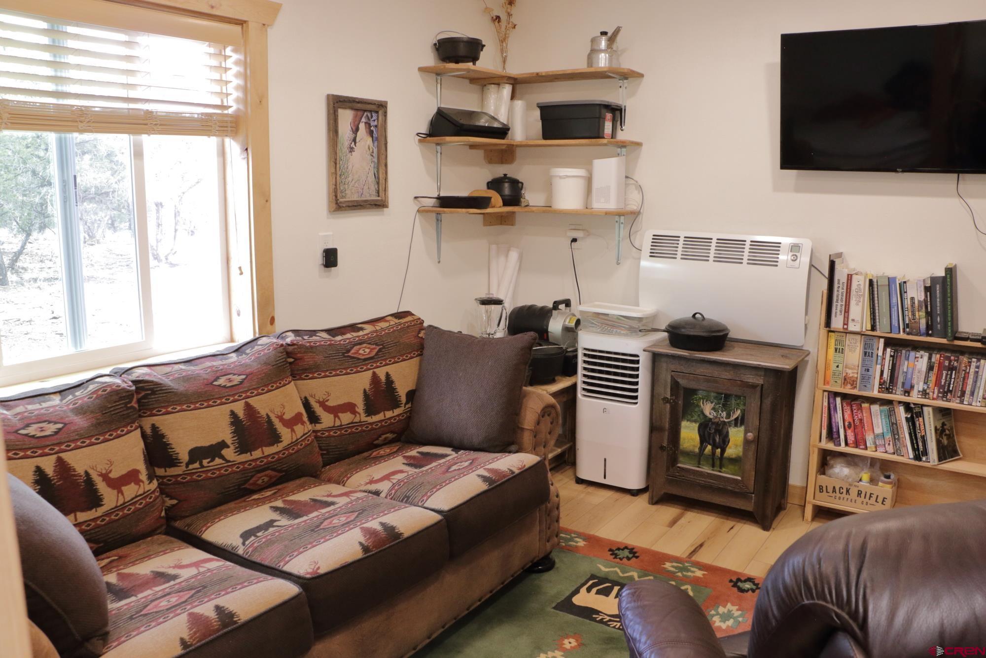 75707 B76 Road Crawford, CO 81415 - Photo 30 of 44 a living room with furniture a flat screen tv and a bookshelf