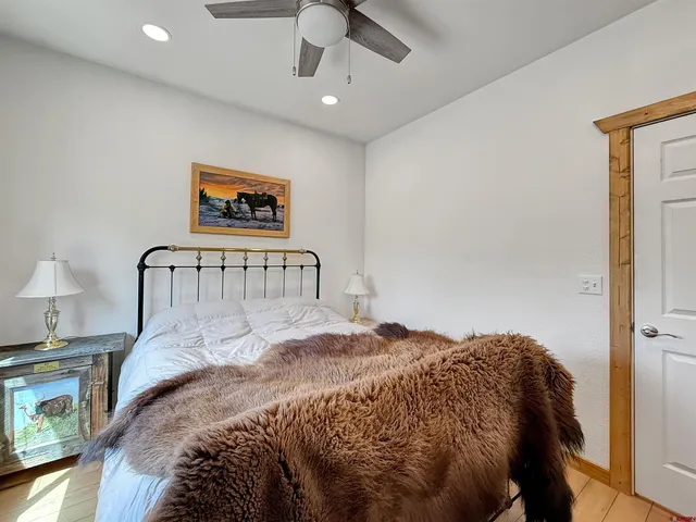 a bedroom with a bed and a ceiling fan