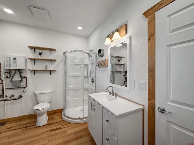 a bathroom with a sink a toilet and shower