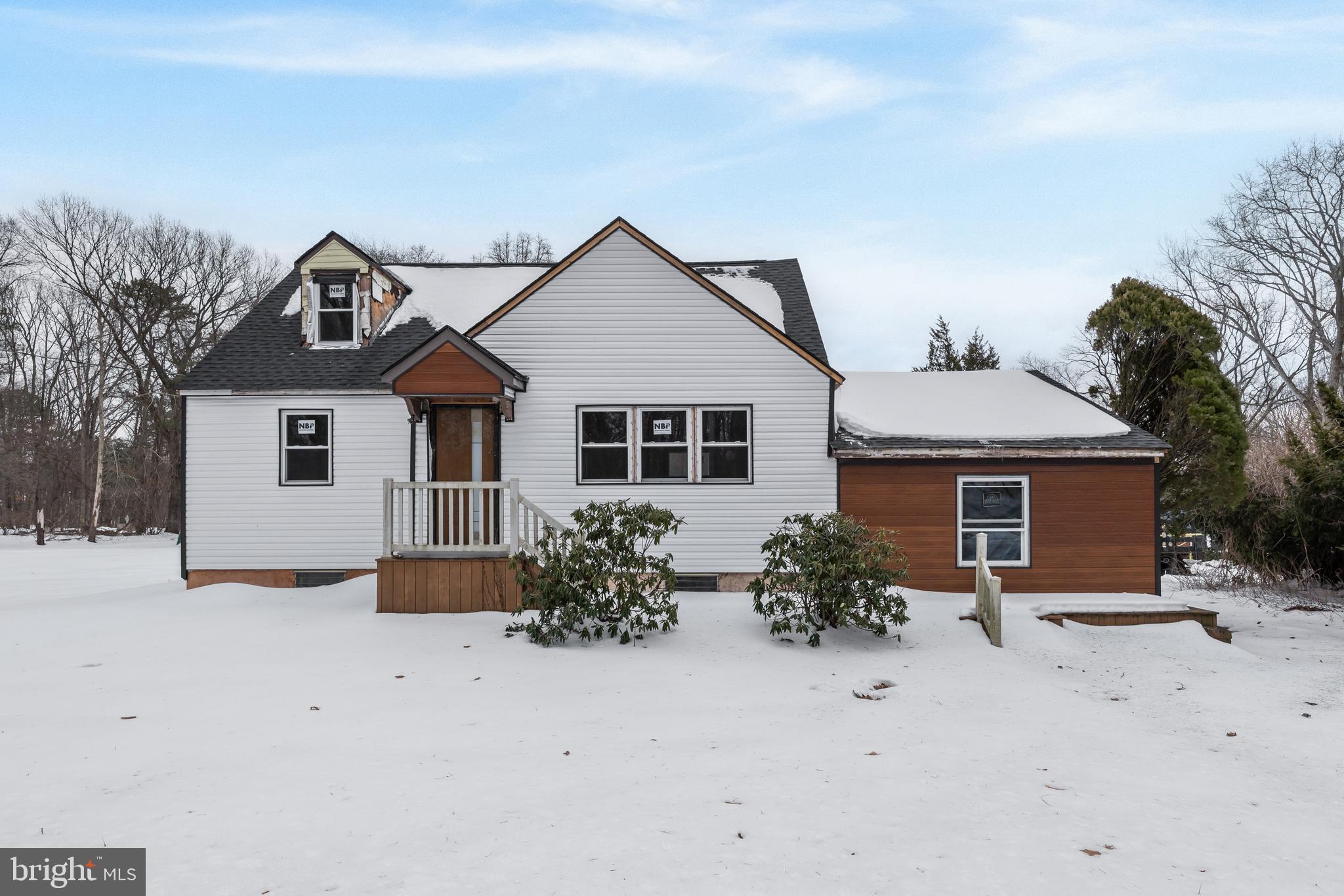 a front view of house with yard and trees in the background