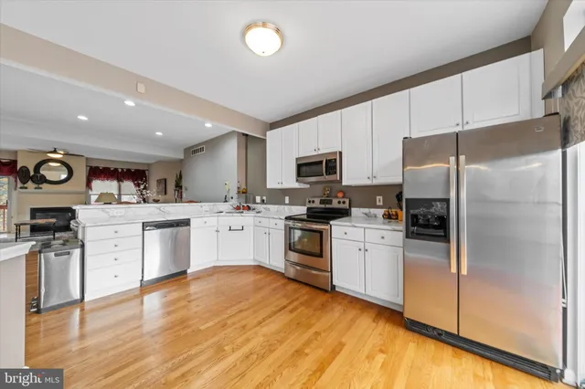 a kitchen with white cabinets stainless steel appliances and sink