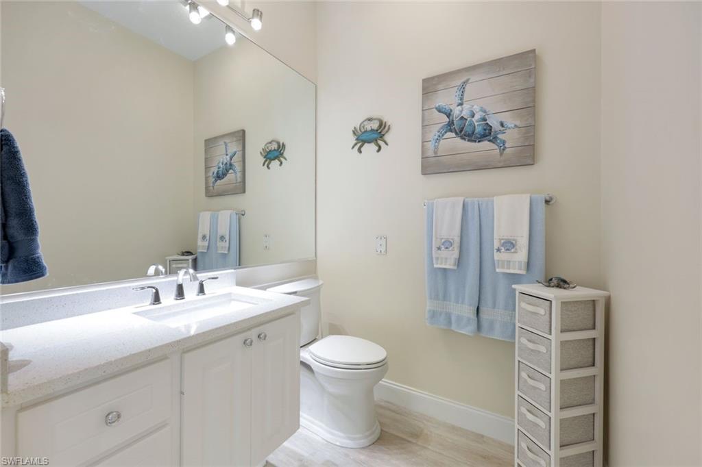 3108 Dominica Way Naples, FL 34119 - Photo 14 of 39 Bathroom featuring a white vanity with a light-colored countertop, an undermount sink, and a chrome faucet.