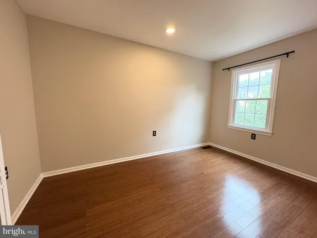 an empty room with wooden floor and closet