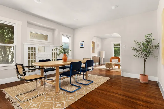 a living room with furniture a potted plant and a large window