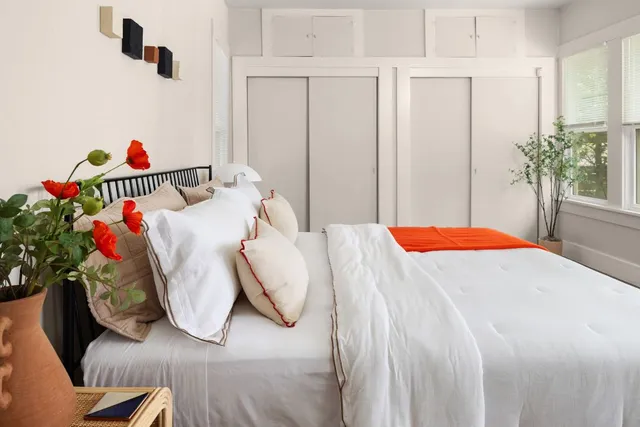 a bedroom with a bed and a potted plant