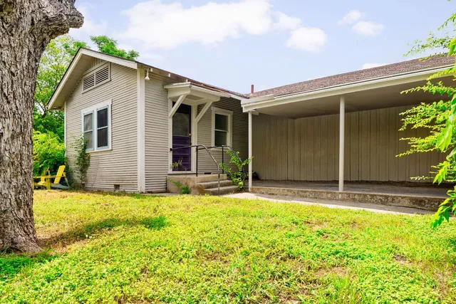 a view of a house with yard and sitting area