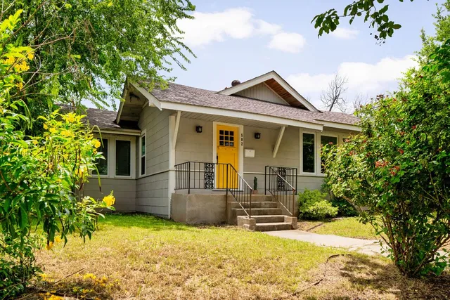 a view of house with backyard and glass windows
