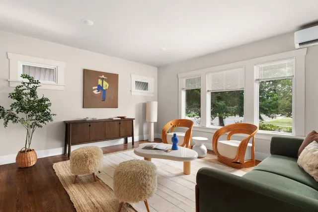 a living room with furniture large window and potted plants