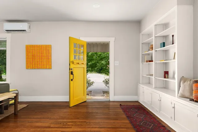 a view of an entryway with wooden floor and cabinet