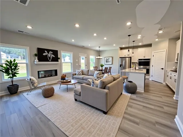 a living room with furniture a fireplace a flat screen tv and potted plant