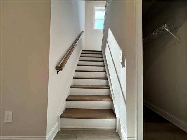 a view of staircase with wooden floor and white walls