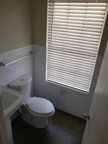 a bathroom with a toilet and a window