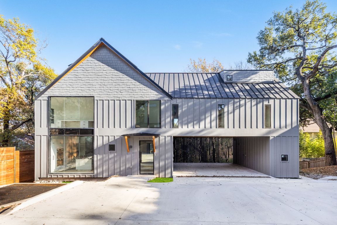 View of front facade with board and batten siding, a metal roof, and a standing seam roof