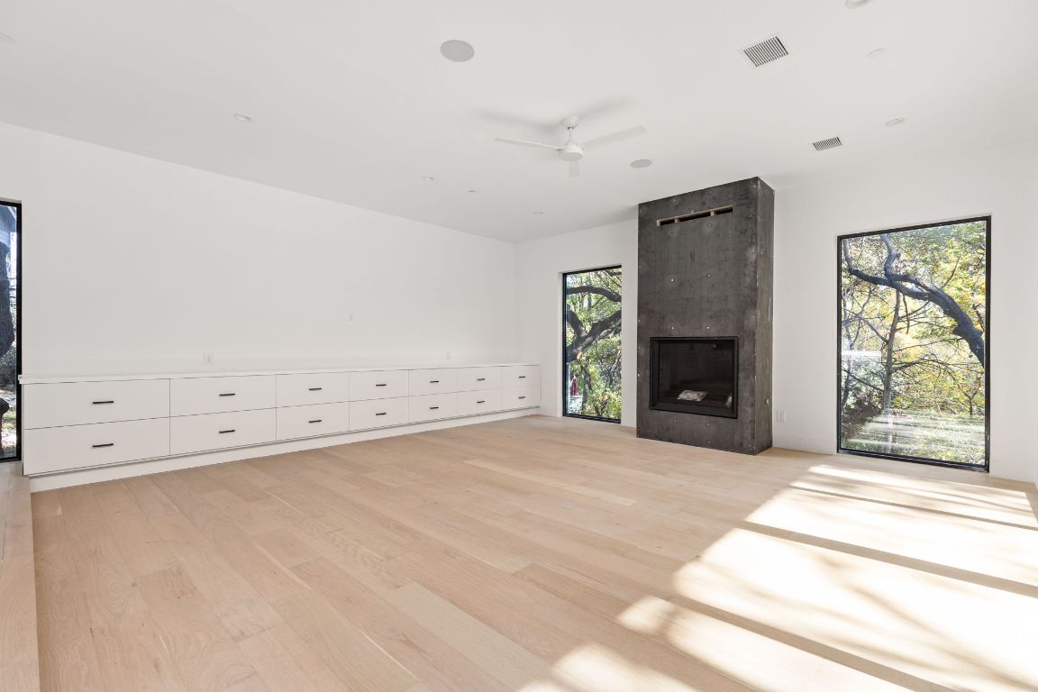 1603 Chelsea Lane, Unit 3 Austin, TX 78704 - Photo 11 of 40 Unfurnished living room with light wood-type flooring, a ceiling fan, and a fireplace