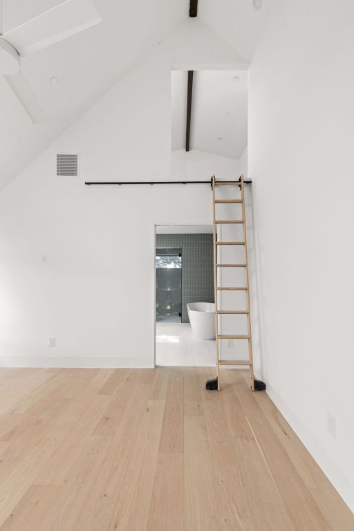 1603 Chelsea Lane, Unit 3 Austin, TX 78704 - Photo 15 of 40 Empty room with beamed ceiling, light wood-style flooring, and high vaulted ceiling