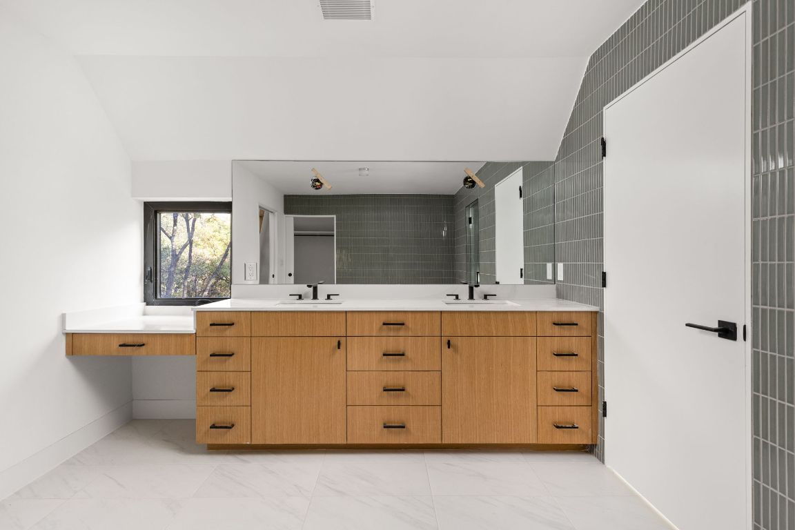 1603 Chelsea Lane, Unit 3 Austin, TX 78704 - Photo 17 of 40 Bathroom with double vanity, lofted ceiling, light marble finish floors, and a walk in shower
