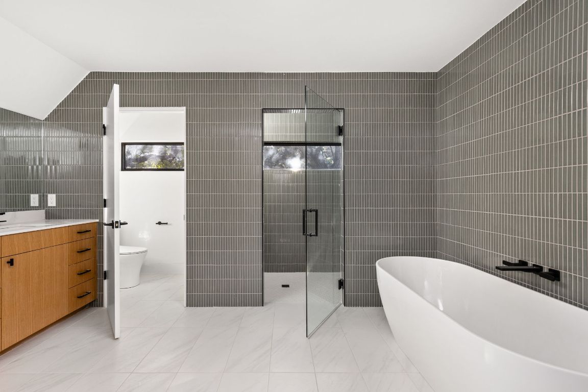1603 Chelsea Lane, Unit 3 Austin, TX 78704 - Photo 19 of 40 Bathroom featuring tile walls, a soaking tub, a stall shower, vanity, and light tile patterned floors