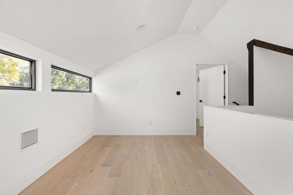 1603 Chelsea Lane, Unit 3 Austin, TX 78704 - Photo 30 of 40 Unfurnished room with light wood finished floors and vaulted ceiling