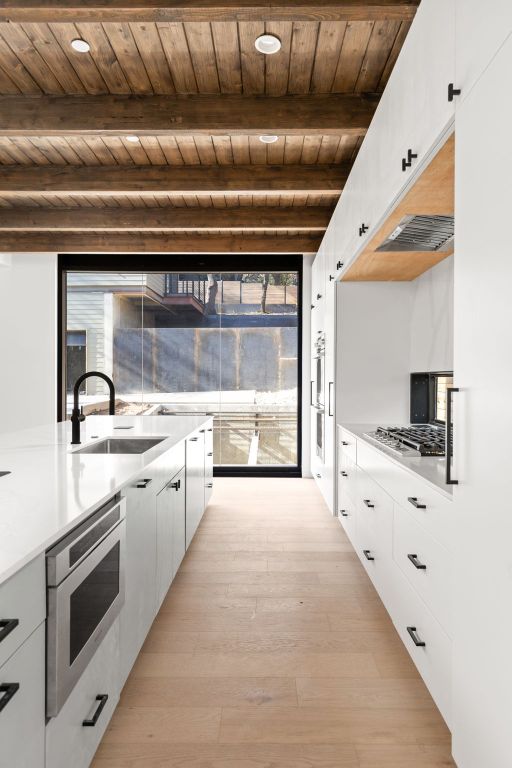 1603 Chelsea Lane, Unit 3 Austin, TX 78704 - Photo 8 of 40 Kitchen with white cabinetry, a wood ceiling with exposed beams, light wood finished floors, and plenty of natural light