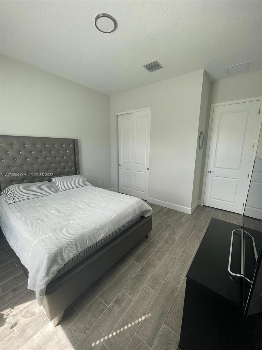 The Acreage Loxahatchee, FL 33470 - Photo 9 of 63 a bedroom with a bed and a refrigerator