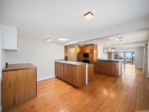 a kitchen with kitchen island wooden floor and stainless steel appliances