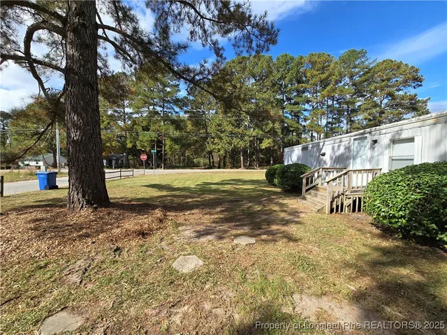 a view of a yard with plants and trees