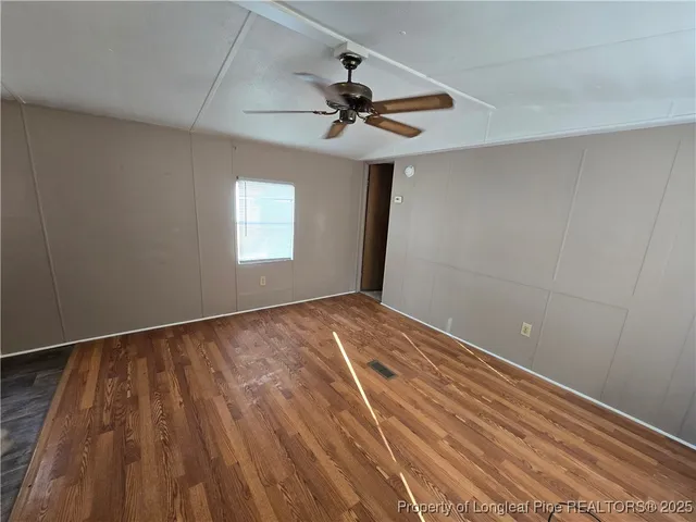 a view of empty room with window and ceiling fan