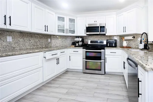 a kitchen with cabinets appliances and a counter space
