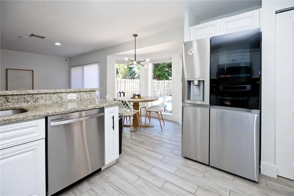 a kitchen with stainless steel appliances granite countertop a stove a sink and a refrigerator