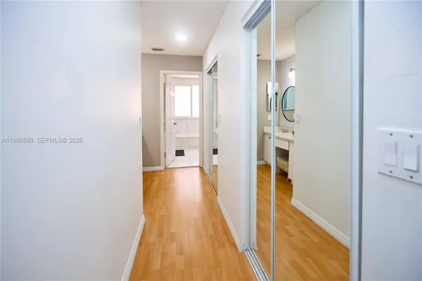 a view of a hallway with wooden floor and staircase