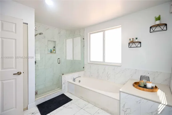 a bathroom with a tub sink and shower